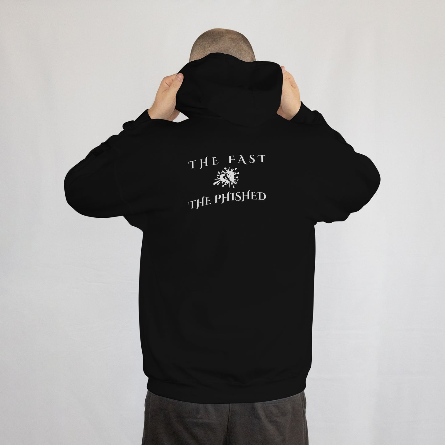 Person wearing a black hoodie with text on the back against a plain background