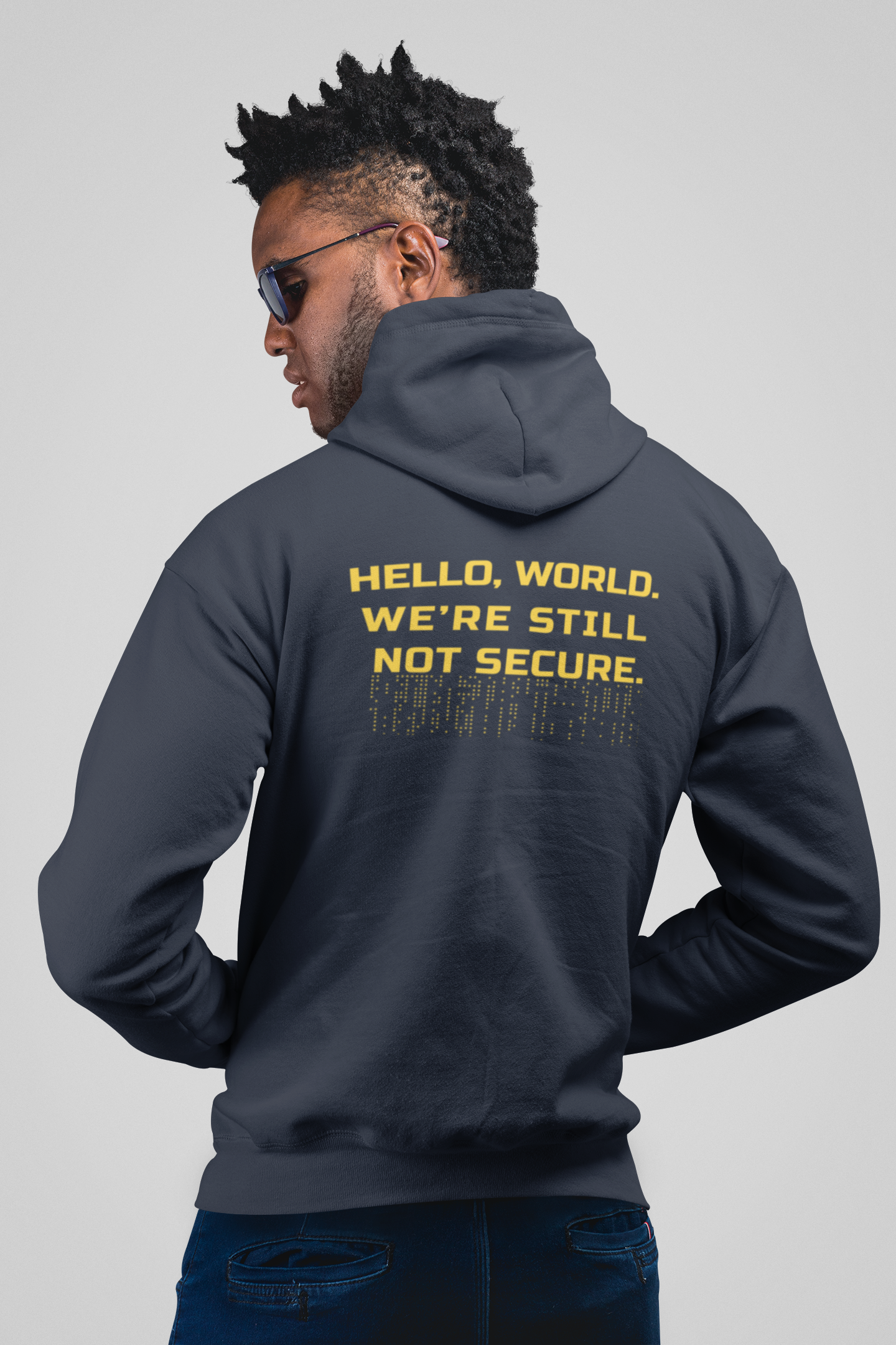 Person wearing a dark hoodie with text on the back against a gray background