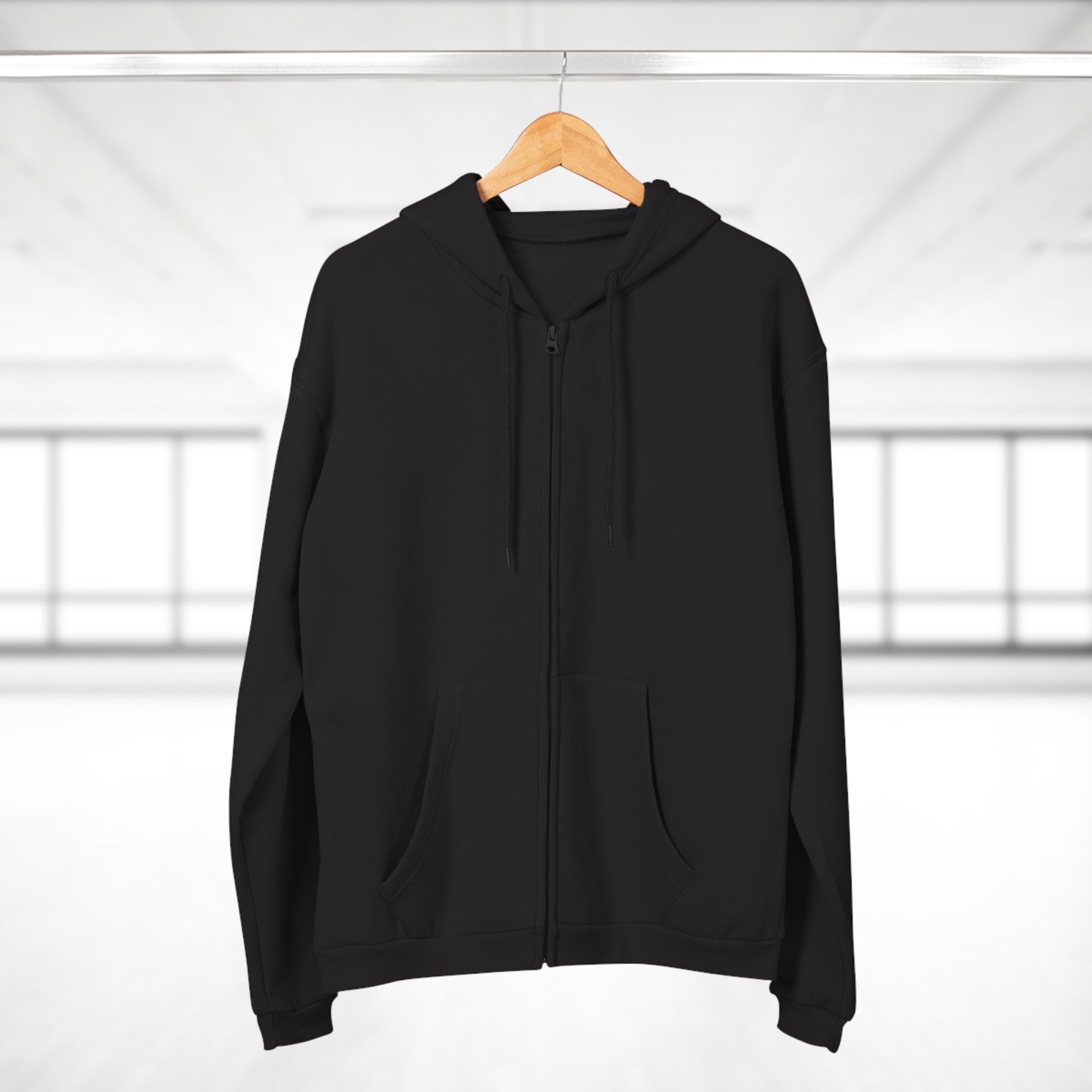 Black hoodie on a wooden hanger against a white background