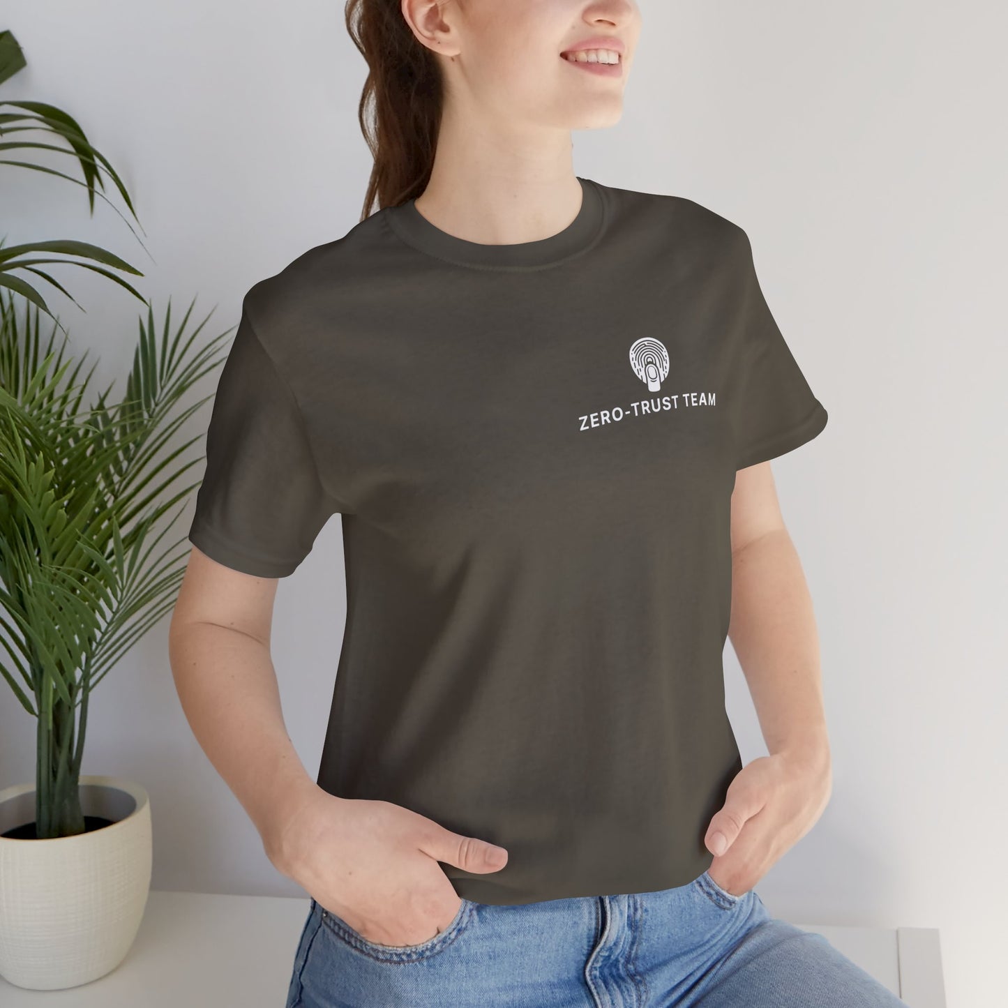 Person wearing a army coloured t-shirt with 'Zero Trust Team' text and logo, standing indoors.
