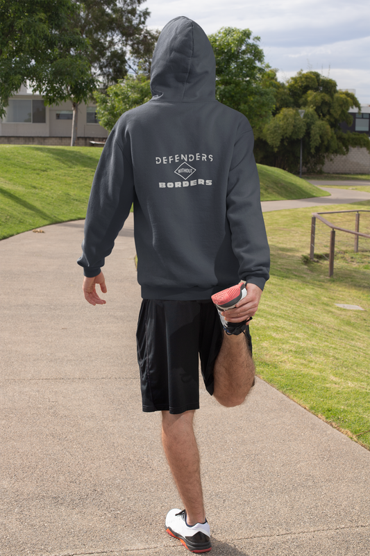 Person wearing a gray hoodie with 'DEFENDERS' branding on a sidewalk.