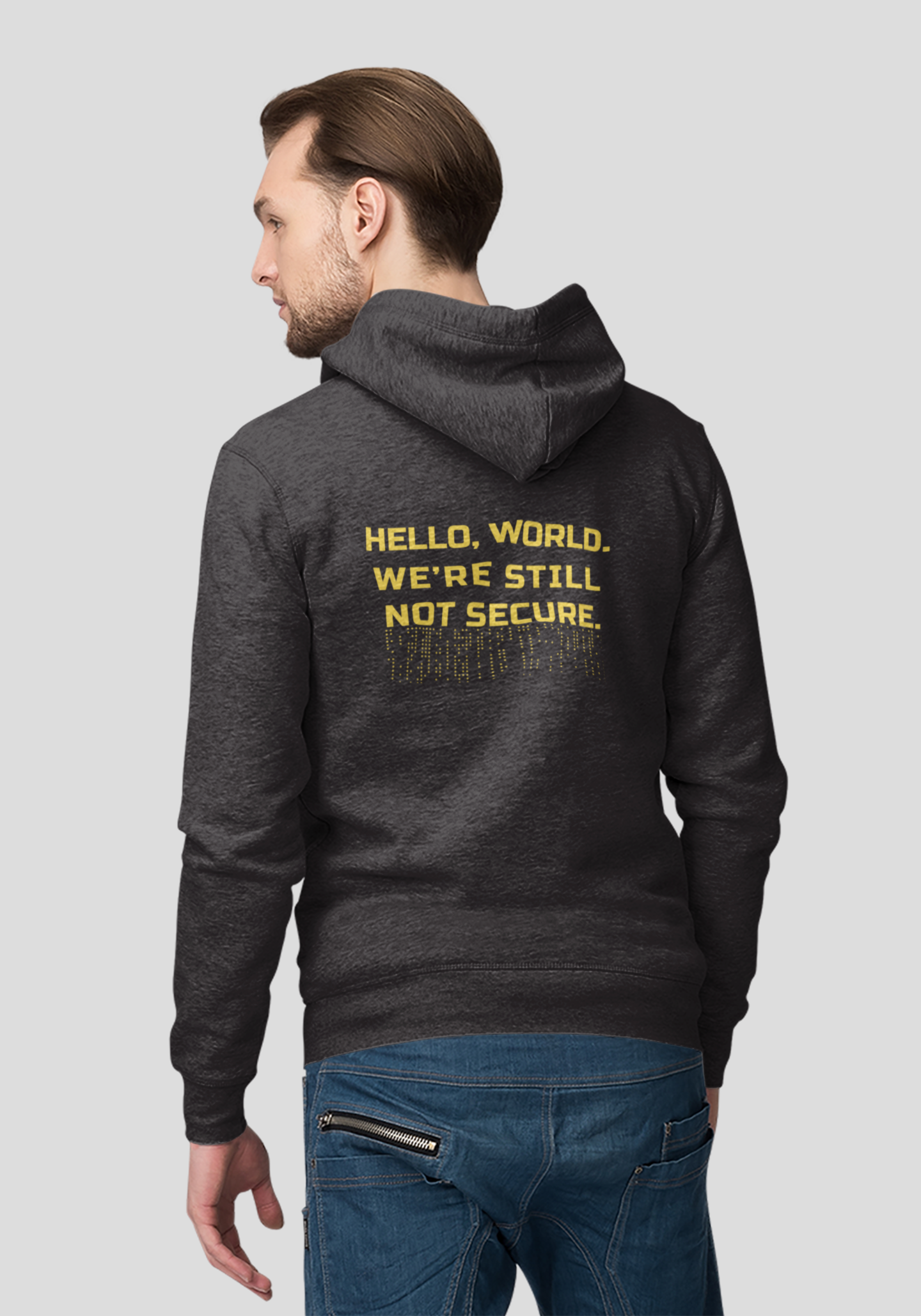 Man wearing a dark hoodie with text on the back, standing against a light gray background
