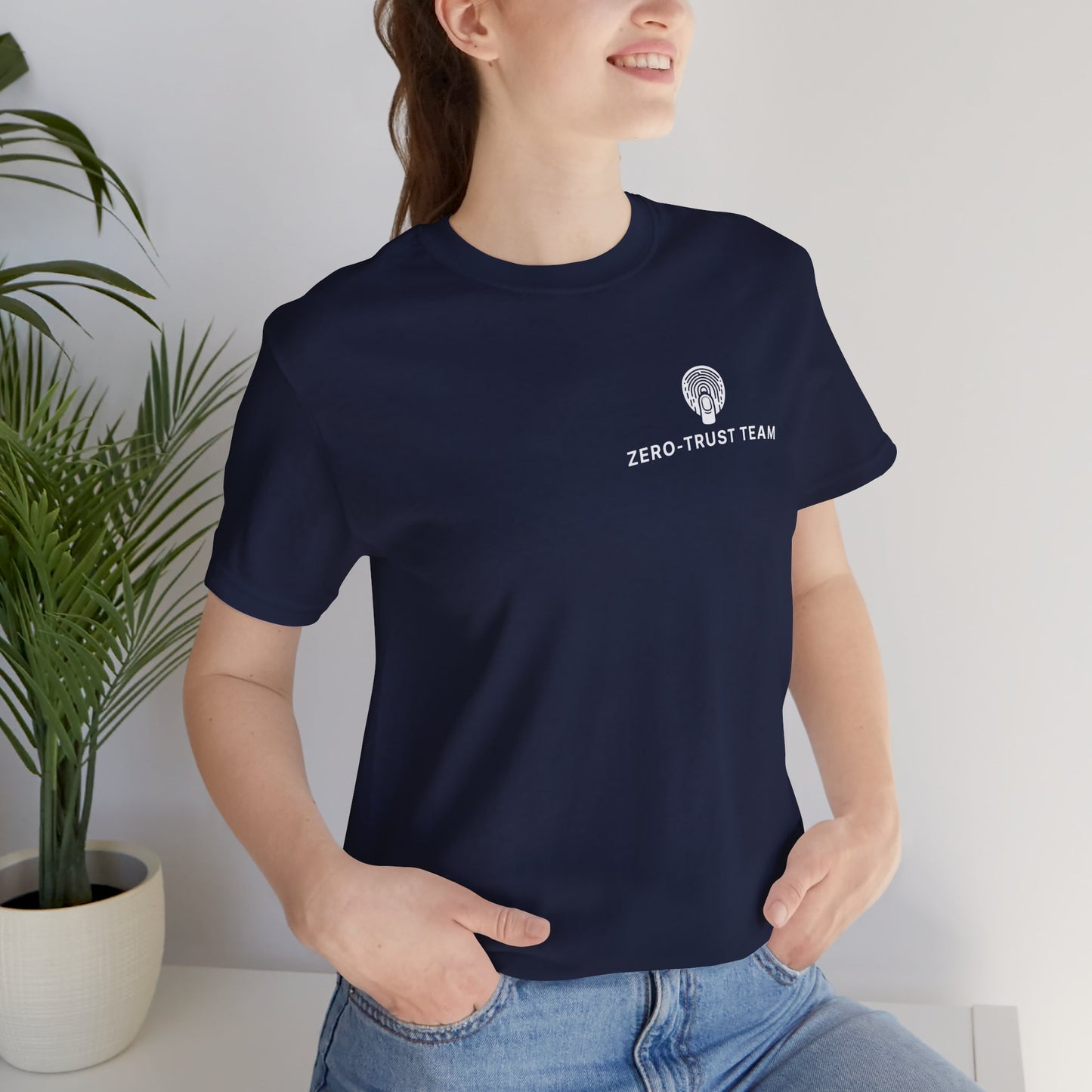 Person wearing a navy blue t-shirt with 'Zero Trust Team' text and logo, standing indoors.